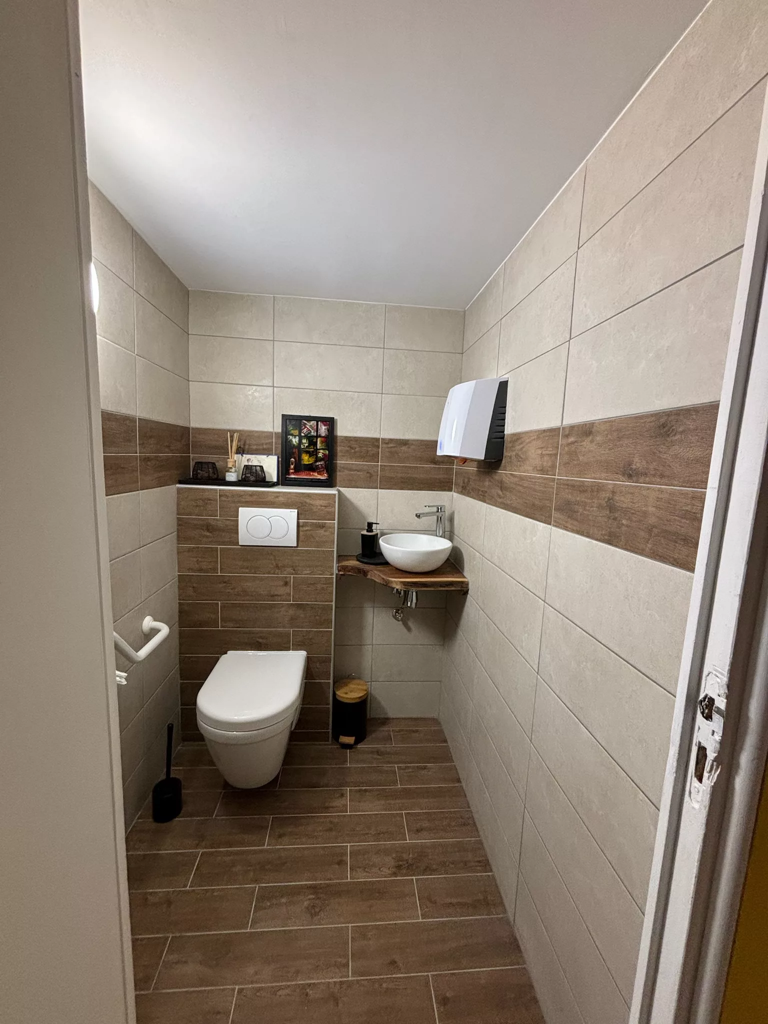 Après — WC rénové avec carrelage effet bois
