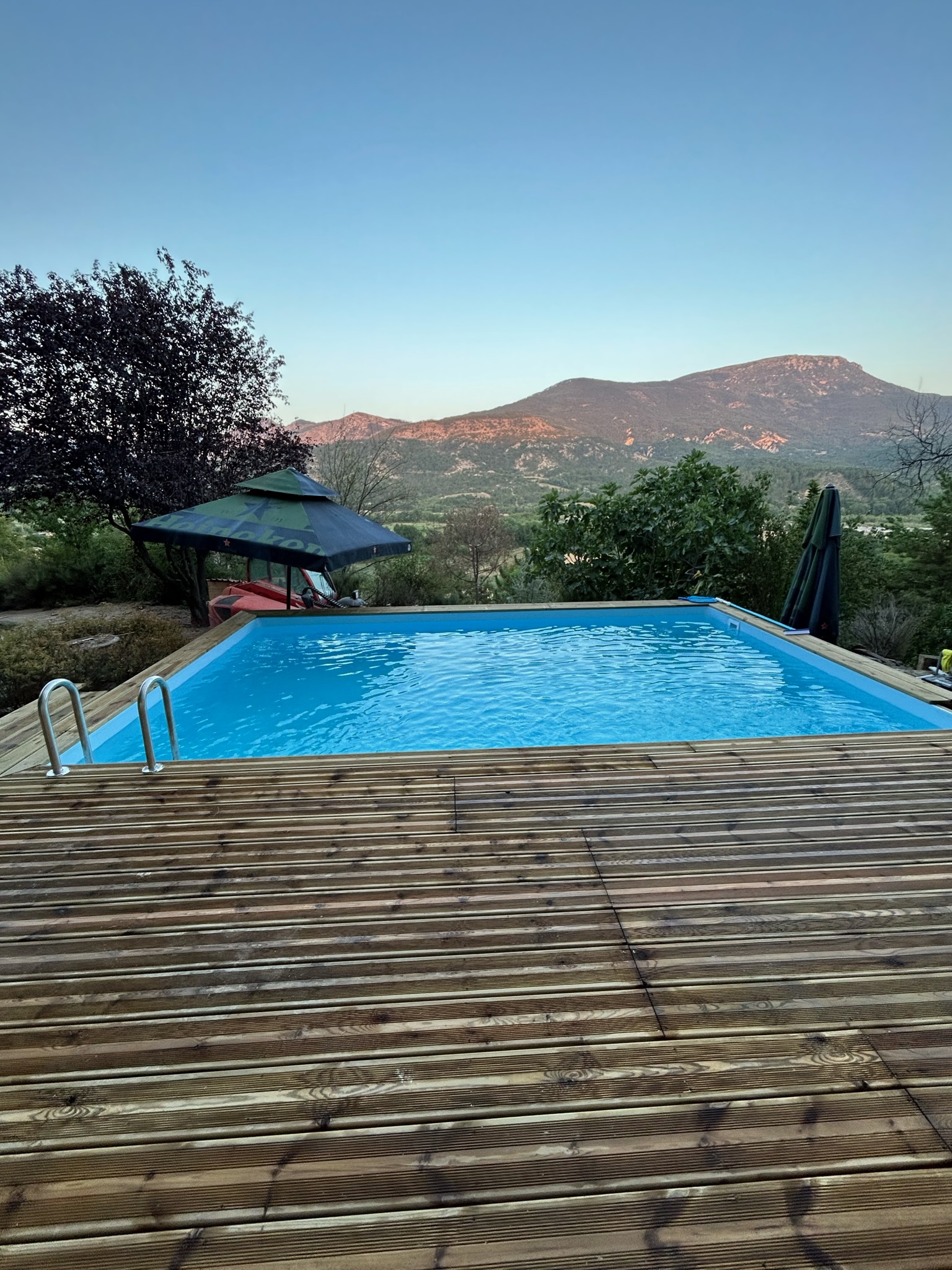 Piscine avec terrasse bois et vue sur la vallée, réalisation JHS